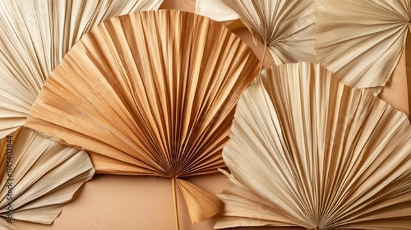 Fototapeta 75.Elegant arrangement of dried palm leaves fanned out to show off their varied shades, from warm beige to deep brown. The natural textures and patterns of the leaves are visible, with each leafâ€™s