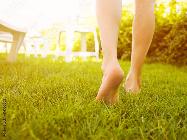 Obraz Close up female legs walking on the grass.