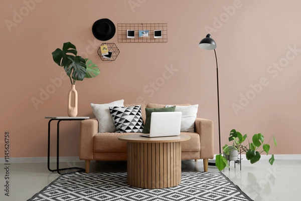 Fototapeta Interior of modern living room with grey sofa, laptop on coffee table and mood board