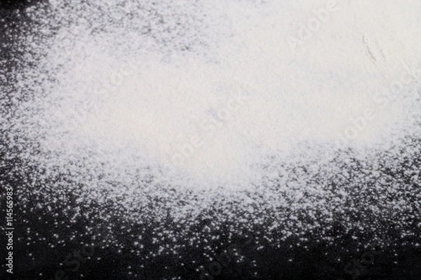 Fototapeta Flour spilling on black background