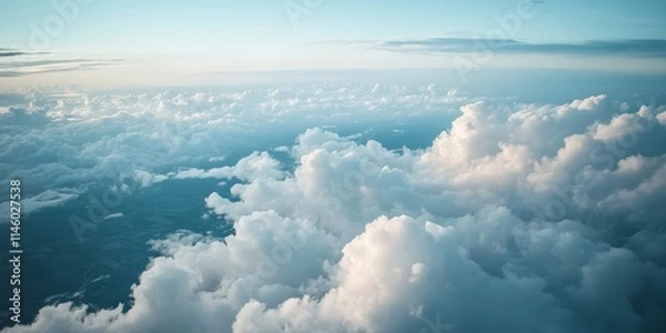 Fototapeta Aerial view of land and clouds captured from an airplane, showcasing the stunning interplay of terrain and cloud formations visible during the flight from the airplane perspective.