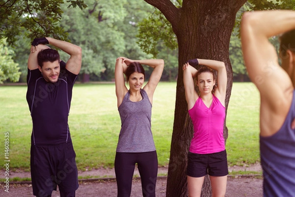 Fototapeta team dehnt die arme nach dem training