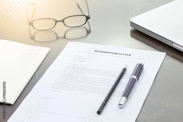 Fototapeta Resignation letter information with pen, pencil, computer laptop and glasses.