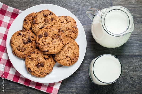 Obraz Chocolate chip cookies, milk, rustic wood background, top view