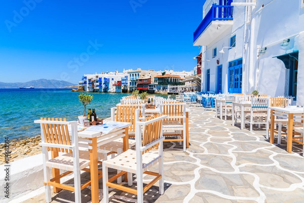 Obraz Krzesła ze stolikami w typowej greckiej tawernie w Little Venice części miasta Mykonos, wyspa Mykonos, Grecja