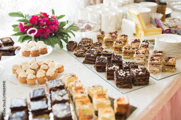 Obraz Delicious and tasty dessert table with cupcakes  shots at reception closeup