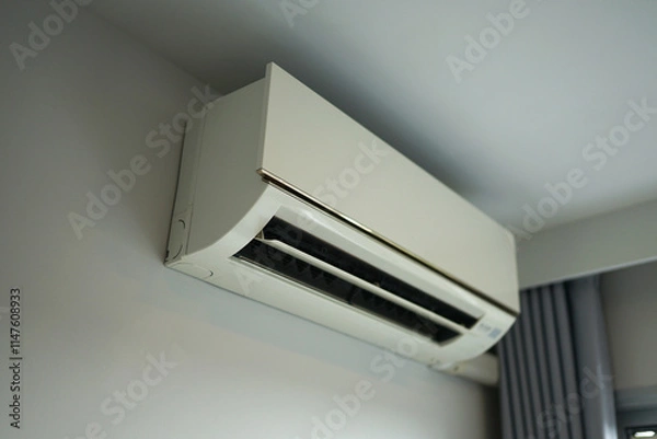 Fototapeta Wall-mounted air conditioner in a modern interior with furniture and natural light