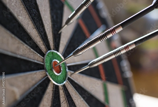 Fototapeta Darts sticking in a dartboard
