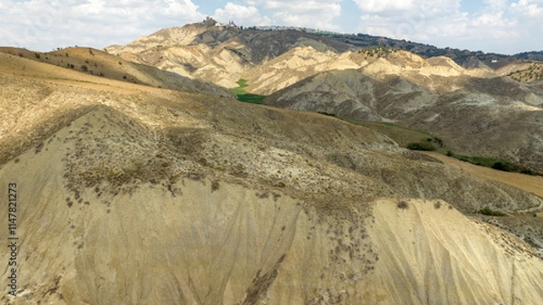 Fototapeta Aerial view of the Calanchi near Pisticci, in the province of Matera, Basilicata, Italy. Badlands are a type of dry terrain where sedimentary rocks and clay-rich soils have been eroded away.