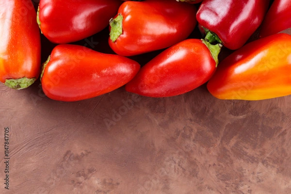 Obraz Colorful Bell Peppers Arranged on Brown Clay Surface for Fresh Vegan Cooking, Copy Space