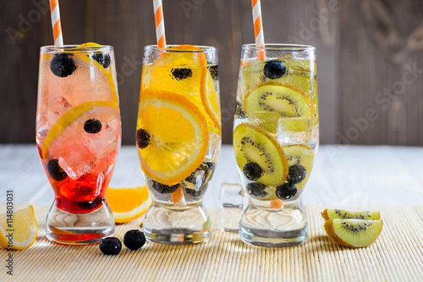Fototapeta Variety of cold lemonade in a glass with fruit and berries