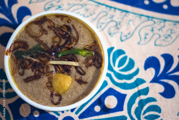 Fototapeta Haleem is a type of stew that is widely consumed in South Asia, Middle East and Central Asia. Composed of meat (mutton, beef or chicken), pounded wheat, lentils, ghee, ginger-garlic.