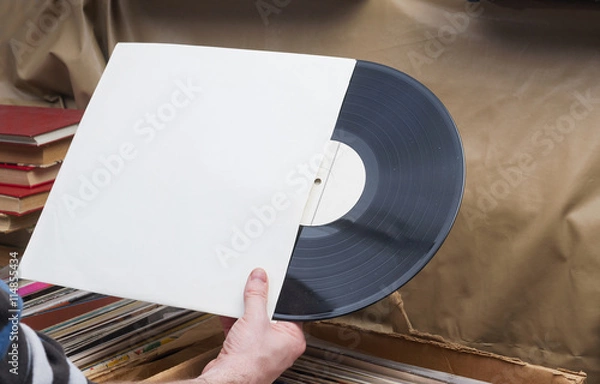 Obraz Retro styled image of a collection of old vinyl record lp's with sleeves on a wooden background. Browsing through vinyl records collection. Music background. Copy space.