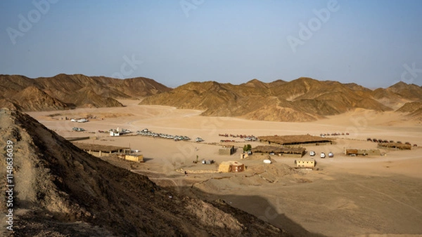 Fototapeta Exploring the Isolated Desert Landscape: Rugged Mountains, Sandy Terrain, and Nomadic Structures Under a Clear Sky, Capturing the Remote and Traditional Lifestyle of a Nomadic Community
