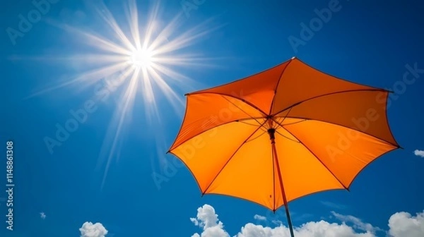 Obraz Orange umbrella against a blue sky with the sun shining, banner background for sun protection and summer vacation