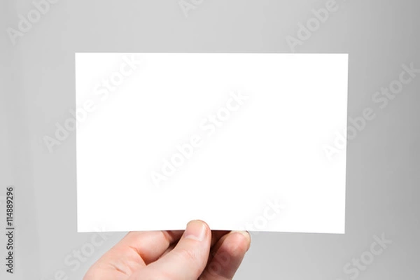 Fototapeta White blank envelope mock up holding in hand. Empty post document design mockup.  Postcard template ready for your logo identity design. Clipping path included
