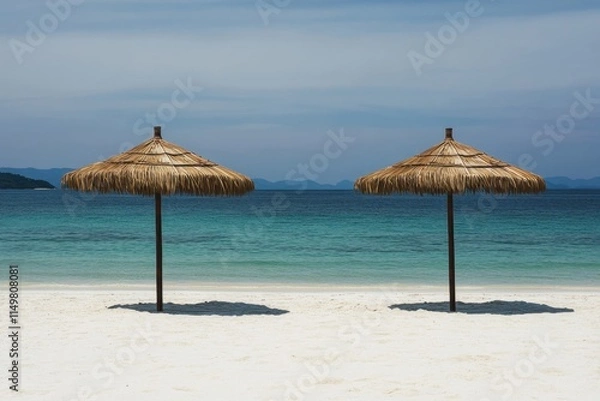 Fototapeta Beachfront with straw umbrellas offering shade beside calm turquoise waters