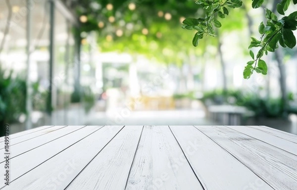 Obraz White wooden table with blurred outdoor cafe background.