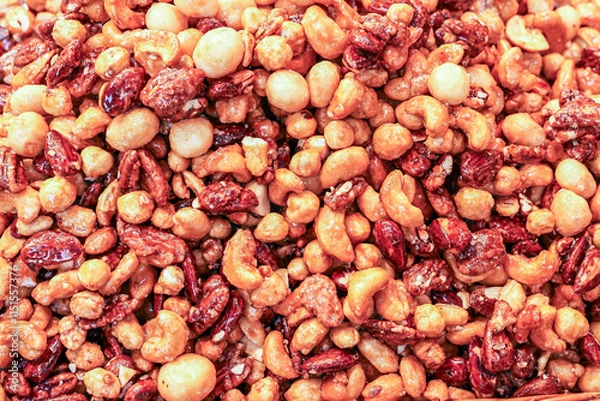 Fototapeta Heaping mound of caramelized nuts, including almonds, pecans, and macadamias, coated in a glossy, sweet syrup, perfect for snacking or as a gourmet gift.