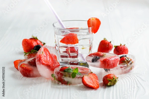 Fototapeta Strawberry lemonade with ice in glass on wooden background