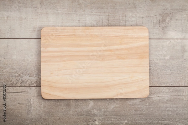 Obraz Wooden cutting board on old wooden table.Top view.