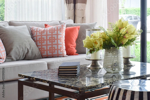 Fototapeta Books and decorative items on marble top table and lively sofa set