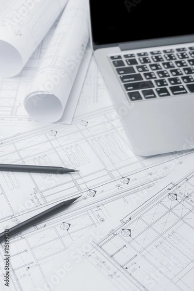 Fototapeta black pencil and computer laptop on architectural drawing paper for construction