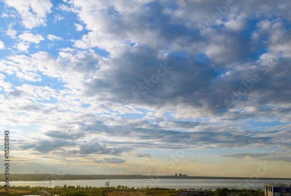 Obraz CHP and other plants stand on the shore of the lake in the evening under clouds in the sky