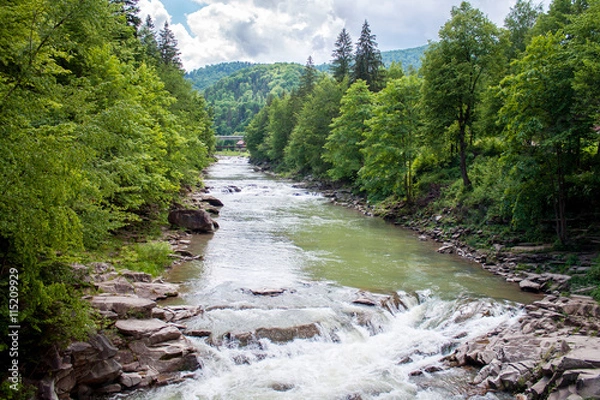 Fototapeta Wide mountain river with rapidly falling blur water. Waterfall 
