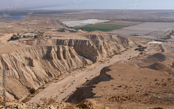 Fototapeta Qumran, an archaeological site located on a dry marl plateau near the northwestern shore of Dead Sea. Caves of Qumran. A dry bed of Qumran stream. Panorama of Qumran National Park. Tourist destination