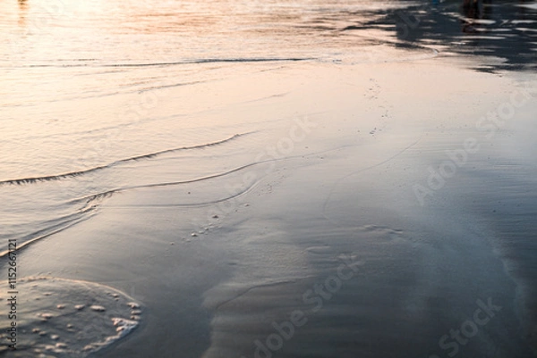 Fototapeta Tranquil beach shoreline with gentle waves under soft evening light