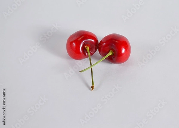 Fototapeta Two red cherries intertwine
