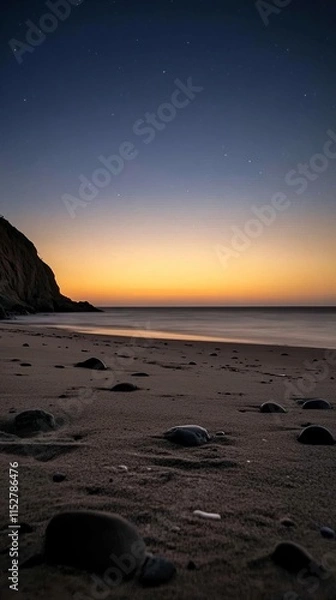 Fototapeta Serene beach at dusk with gentle waves and starry sky in the background.