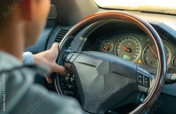 Fototapeta Driving with a car . View from car inside. Steering wheel with man hand
