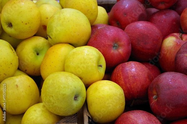 Fototapeta Yellow and red apples mixing in crates at market place