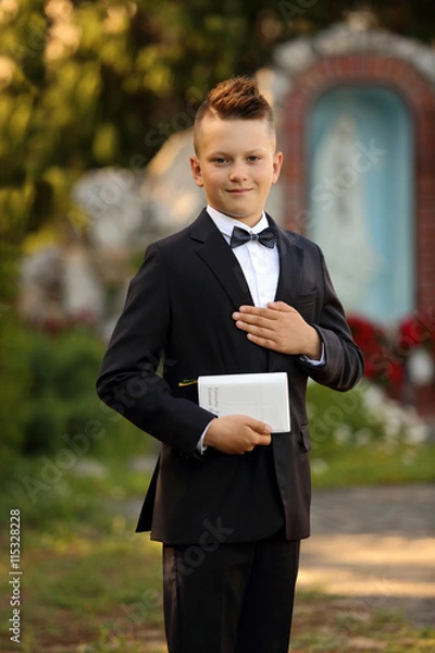 Obraz Młody chłopiec z książeczką w garniturze i w muszce.