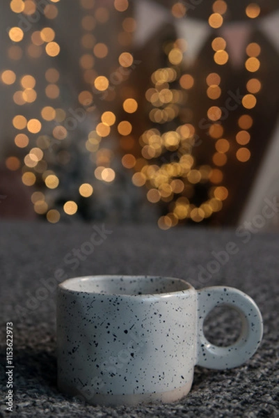 Fototapeta New Year's interior. White cup on blurred bokeh background. Close-up. Copyspace