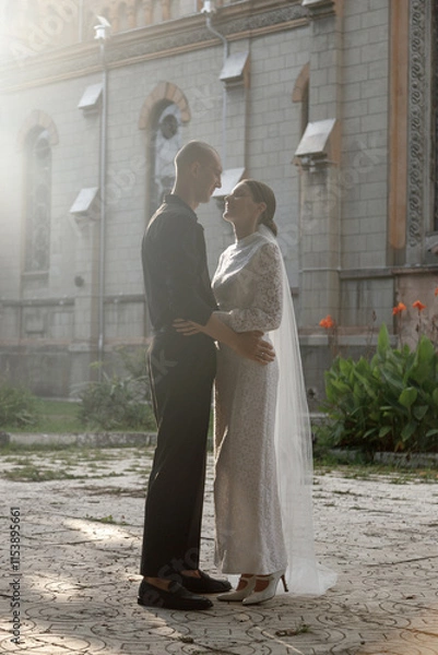 Obraz A Romantic Wedding Kiss Captured in Soft, Radiant Light That Envelops the Couples Affection