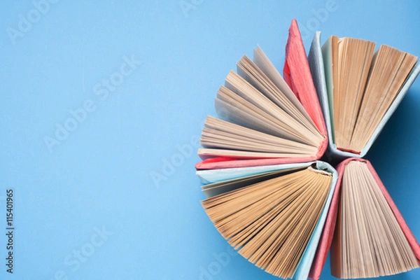 Fototapeta Top view of bright colorful hardback books in a circle. Open book, fanned pages.   Education essential for self improvement, gaining knowledge and success in our careers, business and personal lives.