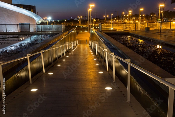 Fototapeta lighted walkway with a fountain on each side