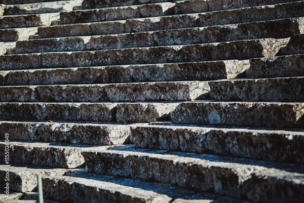 Fototapeta Ancient stone steps of an amphitheater in Greece, showcasing historical architecture with weathered textures and intricate craftsmanship