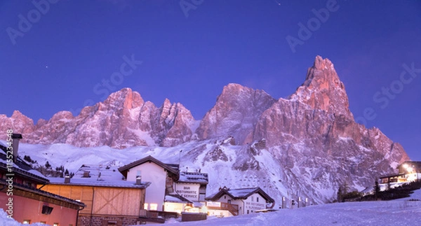 Fototapeta Pale di  San Martino e il Cimon della Pala sulle dolomiti viste dal Passo Rolle al tramonto tra luci suggestive e cielo blu nel paesaggio innevato