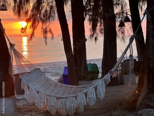 Obraz A hammock sways gently between two trees on a stunning beach