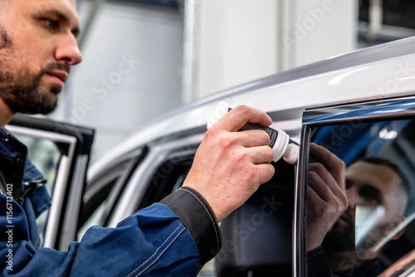 Fototapeta Silicone spray, coating car rubber elements before winter. Lube door channels, ptotect in cold weather. Spraying silicone grease on weather stripping and seals, prevent frozen doo, window
