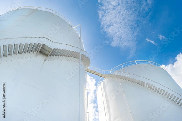 Obraz Zbiornik paliwa i magazyn przemysłowy na niebieskim niebie