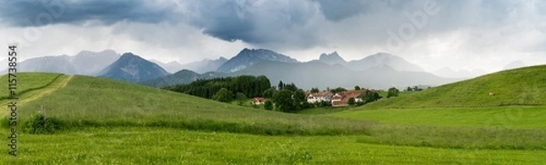 Fototapeta The village in the Alpine valleys and mountains in the mist on the horizon in the south of Bavaria, Germany