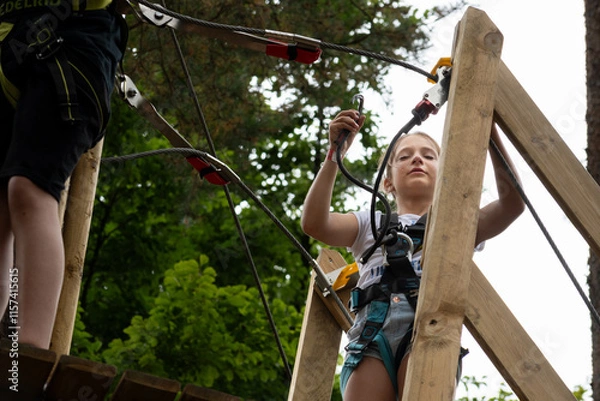 Fototapeta Excitement fills the air as a young girl gets ready to embark on a thrilling zipline adventure, surrounded by lush trees and the sounds of nature.
