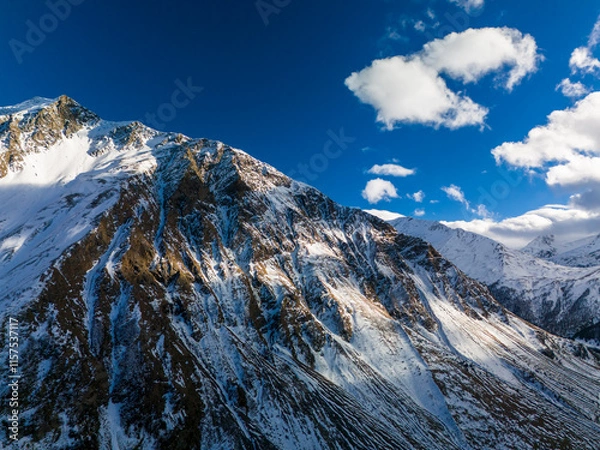 Fototapeta Beautiful aerial view of snowy peaks in a picturesque gorge. Landscape and nature of the North Caucasus