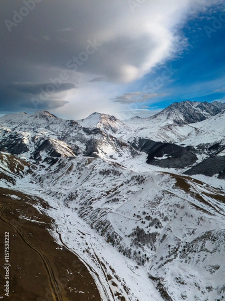 Fototapeta Beautiful aerial view of snowy peaks in a picturesque gorge. Landscape and nature of the North Caucasus