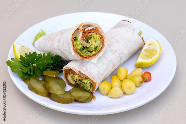 Fototapeta Cig kofte (raw meatball) with lettuce, tomato, pickle and lemon, hot Chee kofta. Turkish local raw food concept.Table scene of assorted take out or delivery foods. Doritoslu duble cig kofte durum.